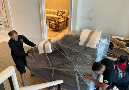 Flat fee movers Queens. Empire Movers and Storage movers moving a piano