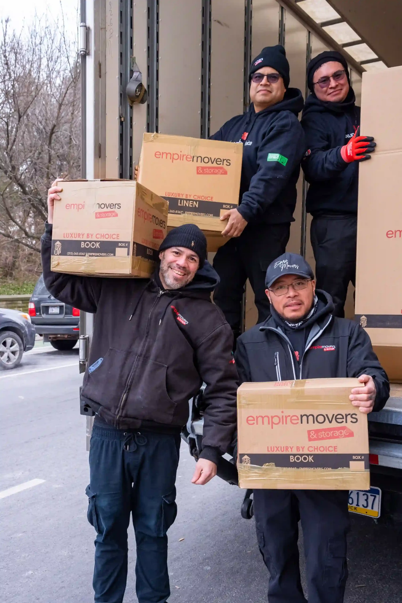NYC local moving team of Empire Movers and Storage posing for a group pic with their truck in the background.